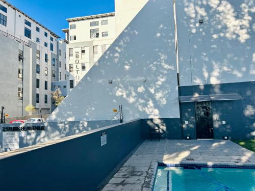 een gebouw met een zwembad aan de zijkant bij Neat and cozy apartment in central Rosebank with unlimited Wi-Fi and backup power in Johannesburg