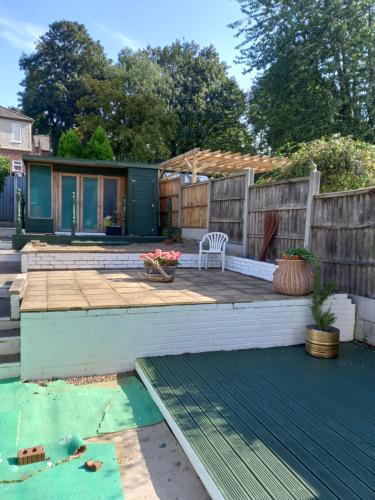 un patio trasero con una terraza de madera y una valla en Jolly Piece en Castleford