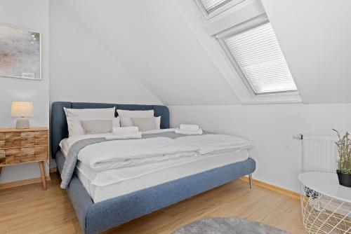 ein Schlafzimmer mit einem blauen Bett in einem weißen Zimmer in der Unterkunft Stilvolle Wohnung: Private Dachterrasse - zentral in Augsburg
