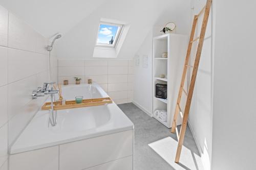 La salle de bains est pourvue d'une baignoire blanche et d'un lavabo. dans l'établissement Stilvolle Wohnung: Private Dachterrasse - zentral, à Augsbourg