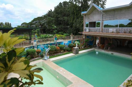 a swimming pool in front of a house at Villa Elsie Resort and Hotel in General Trias