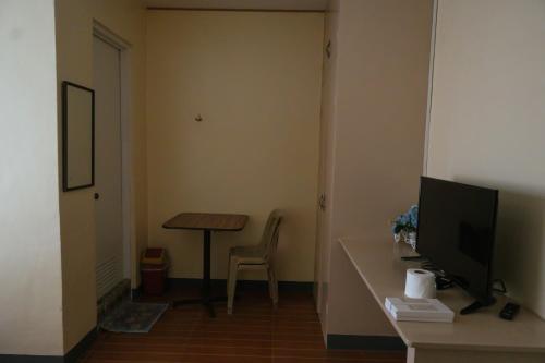 a room with a desk with a television and a table at Villa Elsie Resort and Hotel in General Trias