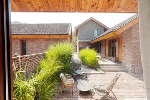 an external view of a patio with chairs and a building at Sansa Village Boutique Hotel at Mutianyu Great Wall in Huairou