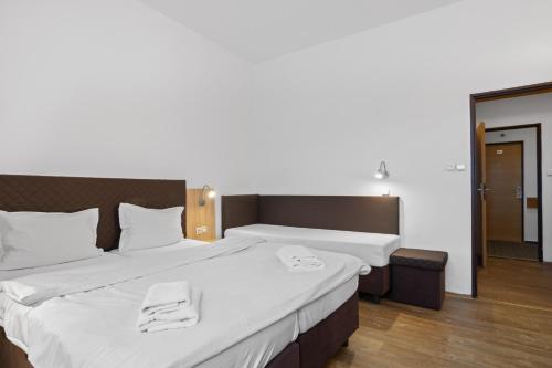 a bedroom with a large bed with towels on it at Hotel Červenohorské sedlo in Loučná nad Desnou
