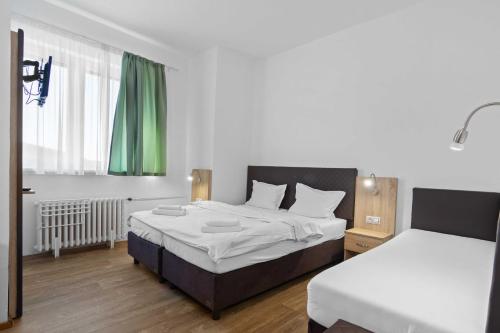 a bedroom with two beds and a window at Hotel Červenohorské sedlo in Loučná nad Desnou