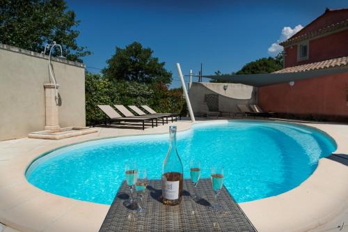 - une bouteille de vin près de la piscine dans l'établissement Le Gite Rouge de Bel Air, à Les Taillades