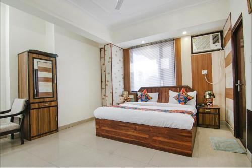 sypialnia z łóżkiem, krzesłem i oknem w obiekcie FabExpress Vistara Grand w mieście Haridwar