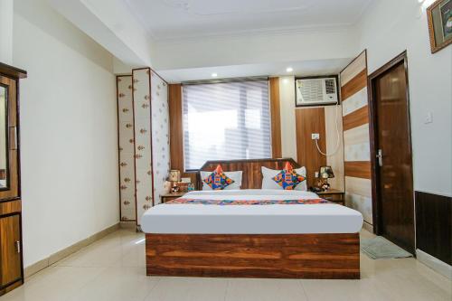 a bedroom with a large wooden bed and a window at FabExpress Vistara Grand in Haridwār