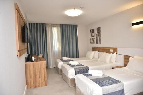 a hotel room with two beds and a television at Old Batumi Hotel in Batumi