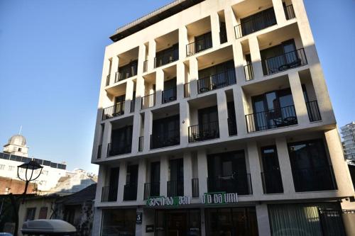 a tall white building with windows and balconies at Old Batumi Hotel in Batumi