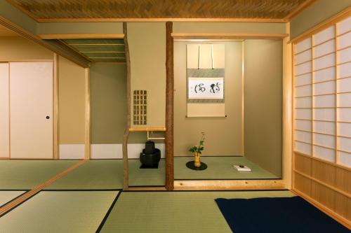 a room with a green floor and a window at Towa Ryokan in Kyoto