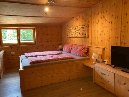 a bedroom with a bed in a wooden cabin at Öfnerhof in Leutasch