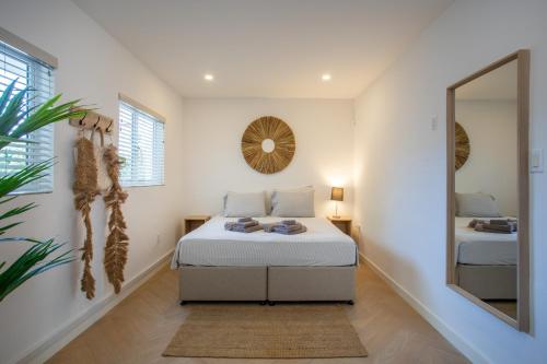 1 dormitorio con cama y espejo en Villa Zarza, en Jan Thiel