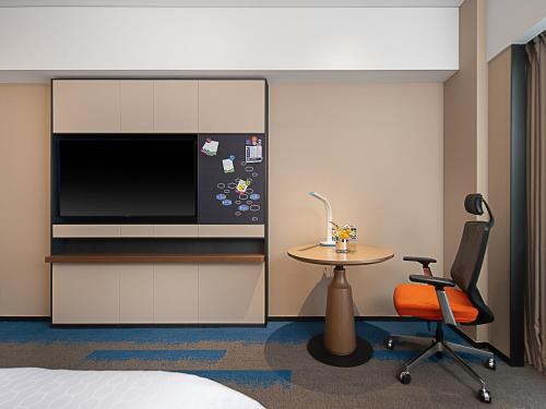 a room with a desk and a chair and a microwave at Hampton by Hilton Guangzhou Railway Station in Guangzhou