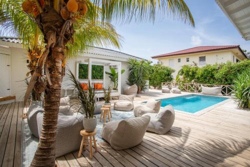 a patio with a palm tree and a swimming pool at Villa Zarza in Jan Thiel
