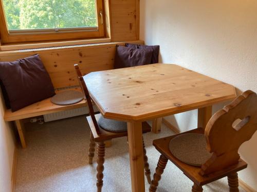 a wooden table and chairs in a room with a window at Öfnerhof in Leutasch