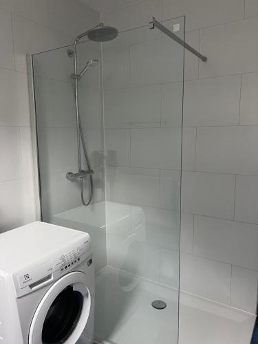a washing machine in a bathroom with a shower at Appartement la Fontaine in Spa