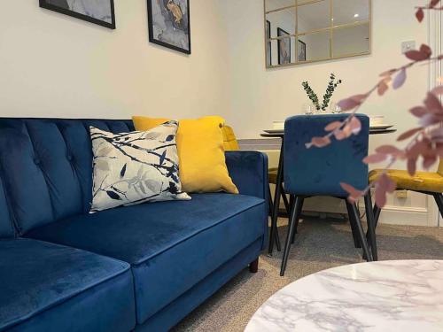 a living room with a blue couch and a table at Rose Court-Free Parking-Central-Long Stay Offer in Rochester