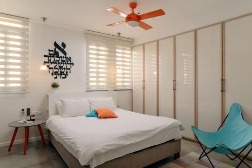 - une chambre avec un lit et une chaise bleue dans l'établissement Stunning 4BR Duplex Penthouse by HolyGuest, à Tel Aviv