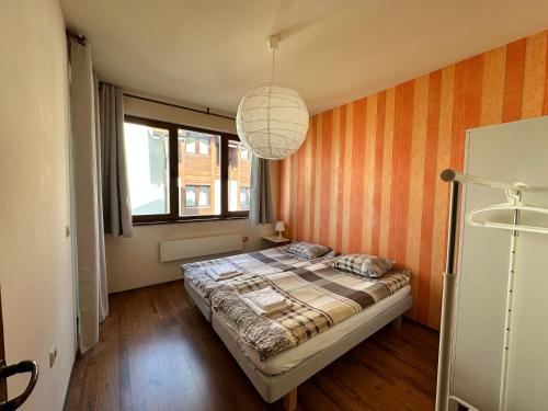 a bedroom with a bed and a large window at Neon Luxury apartments next to the Gondola in Bansko