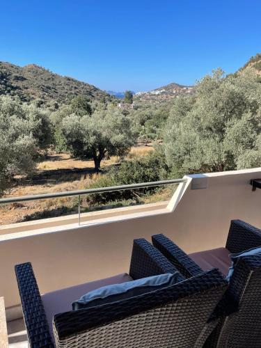 a balcony with chairs and a view of the desert at Meer an Oliven in Agia Galini