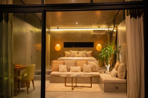 a bedroom with a bed and a couch and a table at Elemen Uluwatu Villas in Uluwatu