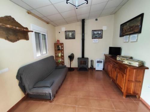 uma sala de estar com um sofá e uma televisão em Casa Rural Mesa Del Lobo Cabrahigo em Sevilha