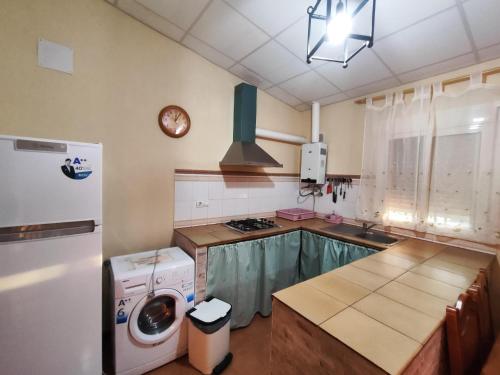 uma cozinha com uma máquina de lavar roupa e um frigorífico em Casa Rural Mesa Del Lobo Cabrahigo em Sevilha