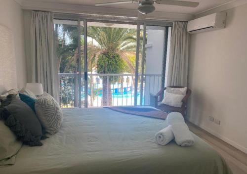 a bedroom with a large bed with a large window at Location Location Location - Broadbeach :) in Gold Coast