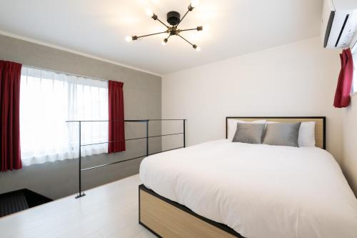 a bedroom with a white bed and a ceiling fan at Laluna Higashiikebukuro in Tokyo