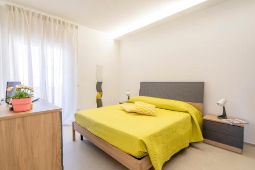 a bedroom with a yellow bed with a yellow blanket at La Casa di Venere with parking in Bari