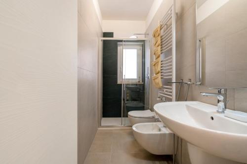 a white bathroom with a sink and a toilet at La Casa di Venere with parking in Bari