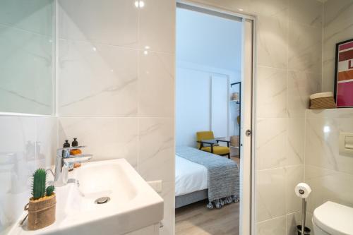 a bathroom with a sink and a shower and a bedroom at Happy Stay Paris - Cosy Studios - 5 min to Eiffel Tower in Paris
