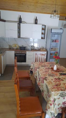 a kitchen with a table and chairs and a kitchen with a table and a counter at Bujtina Lugina e vjosës in Përmet