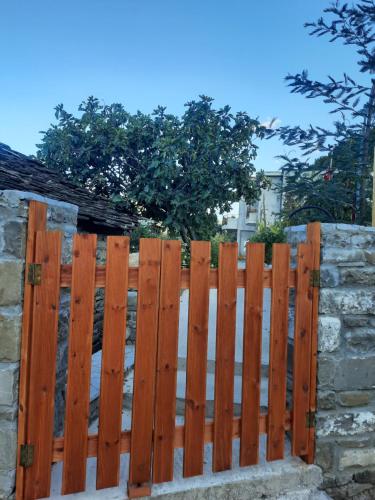 a wooden fence in front of a stone wall at Bujtina Lugina e vjosës in Përmet