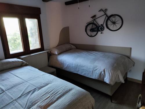 a bedroom with two beds and a bike hanging on the wall at Casa Min in Lasieso