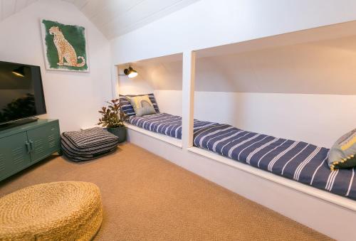 a room with two beds and a flat screen tv at Treforris in Rhosneigr