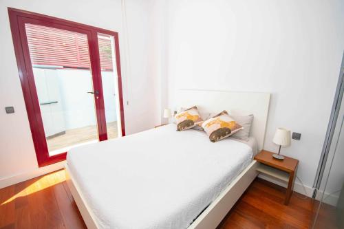 a white bed in a room with a window at Chueca Gran Via Recoletos Libertad 24 2 in Madrid
