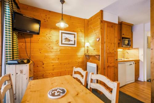 une cuisine et une salle à manger avec une table et des chaises dans l'établissement Résidence Les Sentiers du Tueda - maeva Home - 2 pièces 4 Personnes Confort MAE-9336, à Les Allues