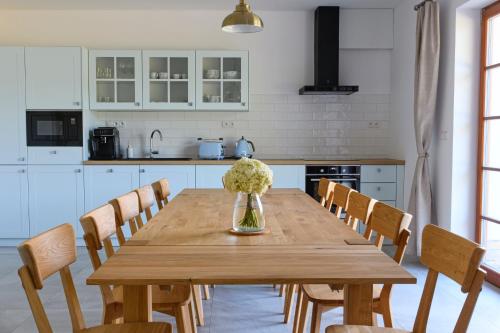 a kitchen with a wooden table with a vase of flowers at Chalupa Pod Šerovnou in Prachatice