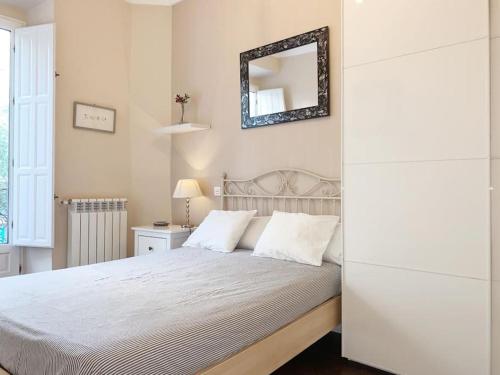 1 dormitorio con 1 cama con espejo en la pared en Apartamento en Atocha Madrid Centro AVE muy grande, en Madrid