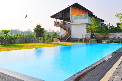 a swimming pool in front of a house at Villa Cinnamon Nature in Beruwala