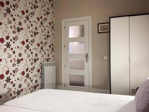 1 dormitorio con cama y pared con estampado de flores en Apartamento en Atocha Madrid Centro AVE muy grande, en Madrid