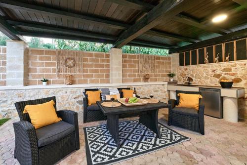 a patio with a table and chairs and an outdoor kitchen at Sunaktis luxury villa in Chania