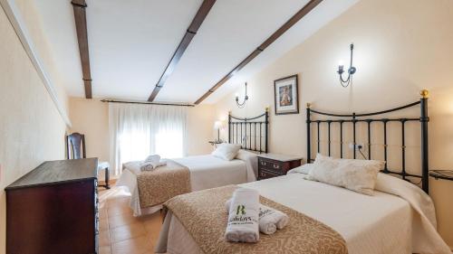 une chambre avec deux lits et une fenêtre dans l'établissement Alojamiento Rural la Aragonesa Marmolejo by Ruralidays, à Marmolejo