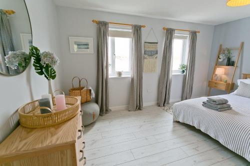 a bedroom with a bed and a mirror at Ty Glan Y Mor in Aberffraw