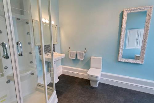 a bathroom with a shower and a toilet and a mirror at Seaforth in Rhosneigr
