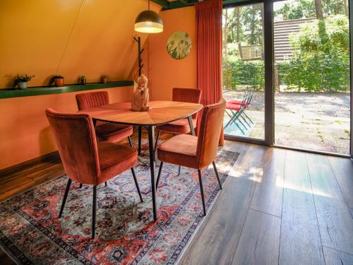 a dining room with a wooden table and chairs at Boshuisje Pinus in Lanaken