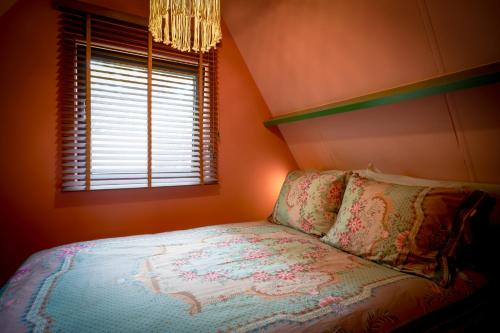 a small bedroom with a bed and a window at Boshuisje Pinus Sonnevijver Residences in Lanaken