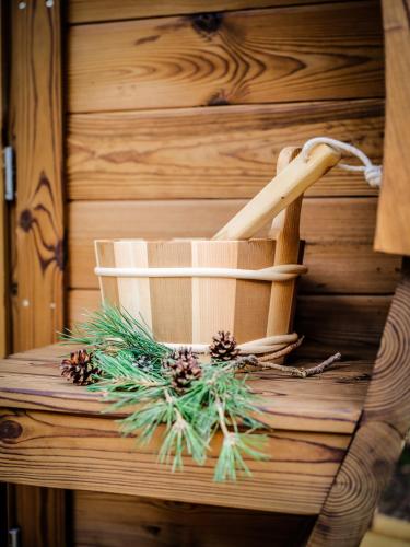 a mortar and pestle on a wooden table with pine needles at Boshuisje Pinus Sonnevijver Residences in Lanaken